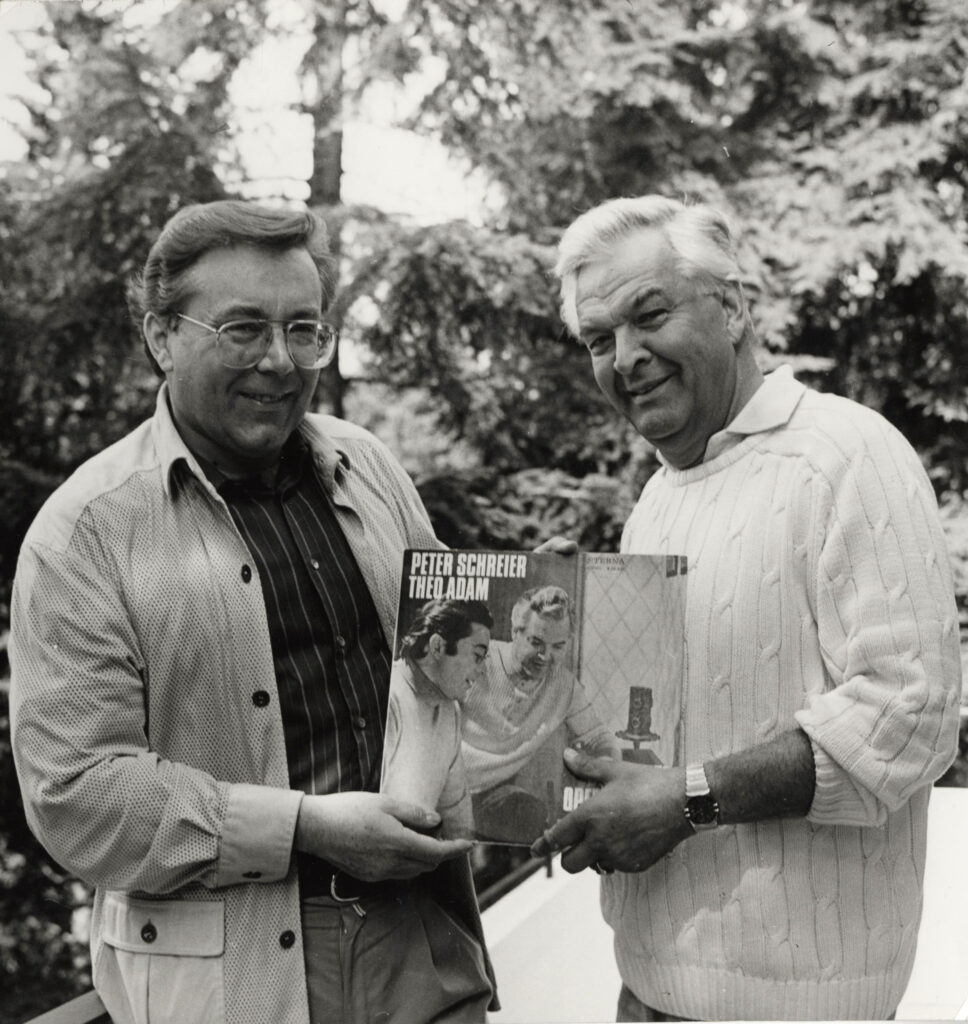 Peter Schreier und Theo Adam stehen gemeinsam mit ihrer Aufnahme "Berühmte Opernduette" in einem Garten.