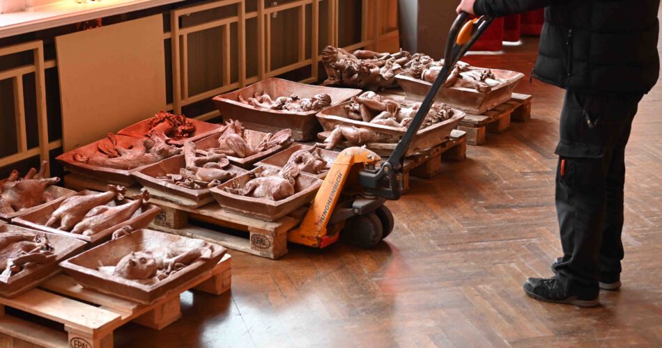 Eine Palette mit mehreren großen Relief-Kacheln wird mit einem Hubwagen angehoben.